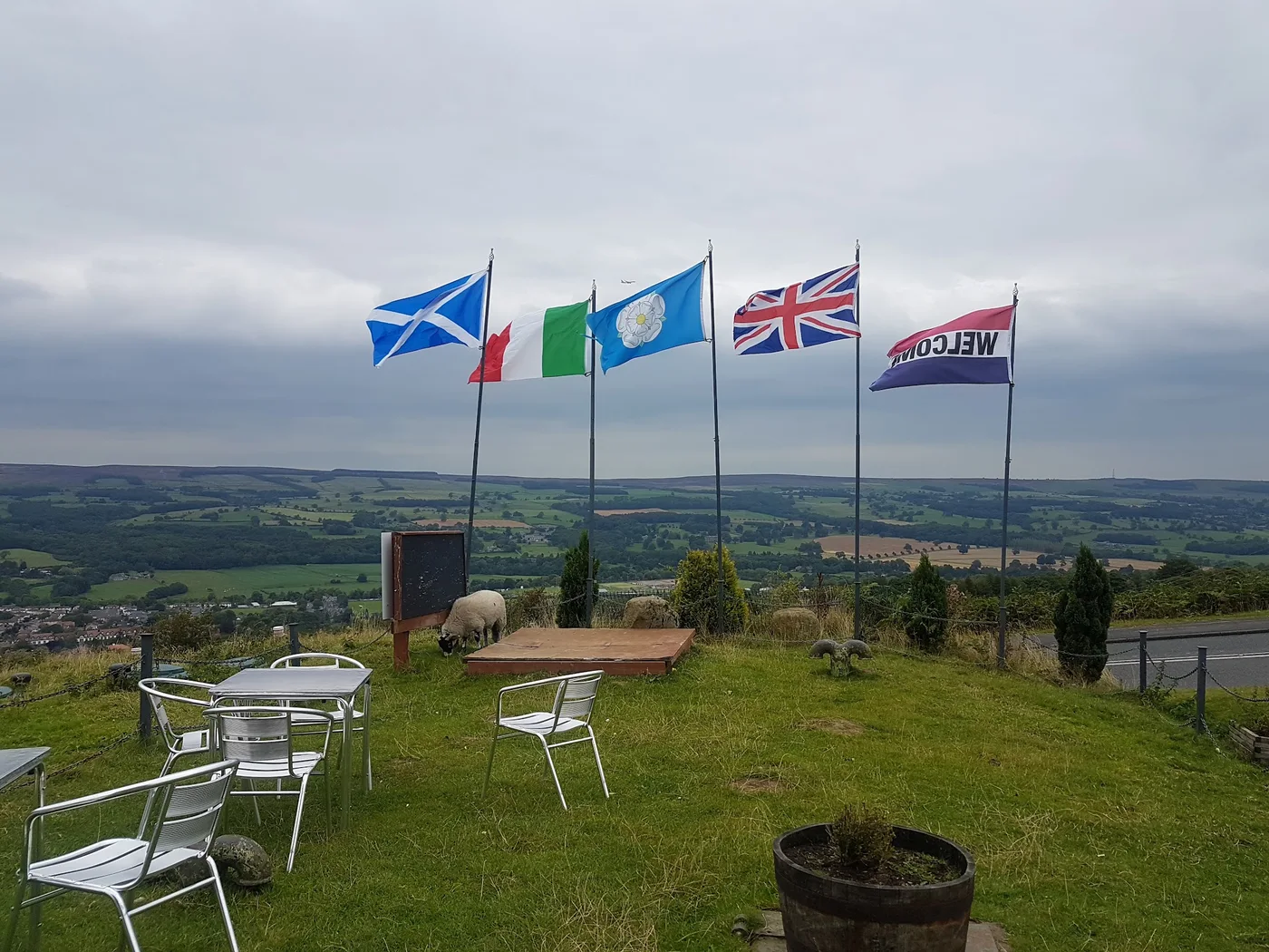 Tables on the cafe terrace overlooking the green valley below Ilkley Moor